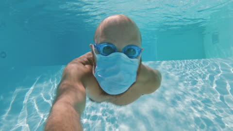 man-swimming-underwater-with-covid-face-mask-protection-in-a-swimming-pool-safe-vacations.jpg