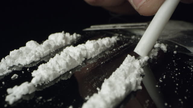 lines-of-cocaine-being-snorted-through-tube-on-table-top.jpg
